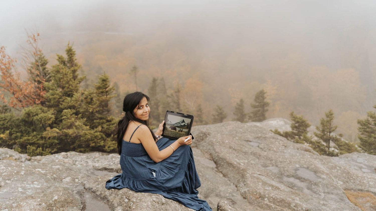 Artist Divya Natur on top of a hill painting an art inspired by Nature