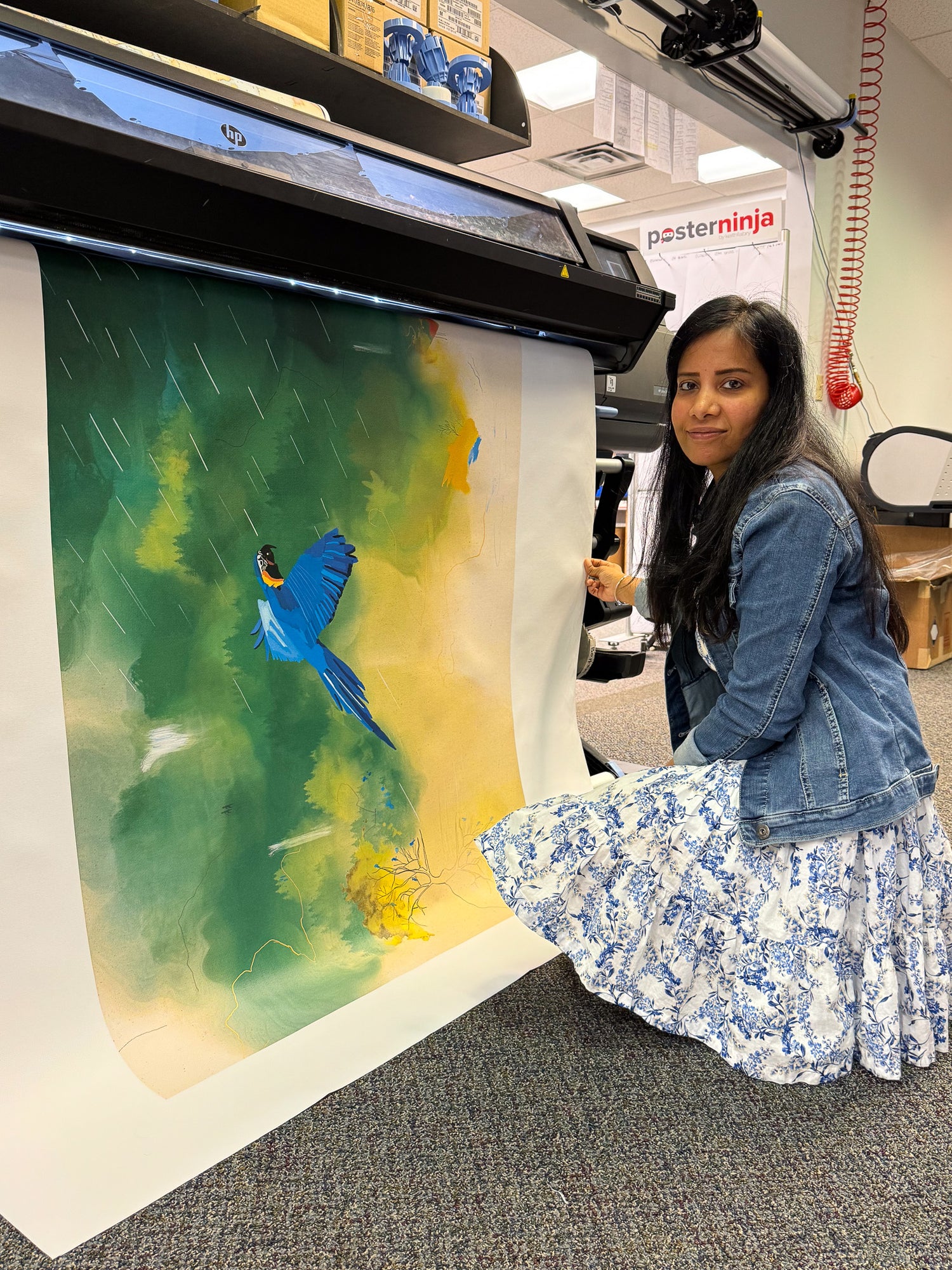 Divya Natur artist holding and testing a large premium artwork print to check professional print quality.