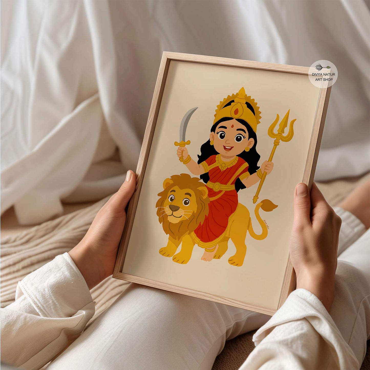 Baby Durga in red saree with golden crown and ornaments, sitting joyfully on her lion.