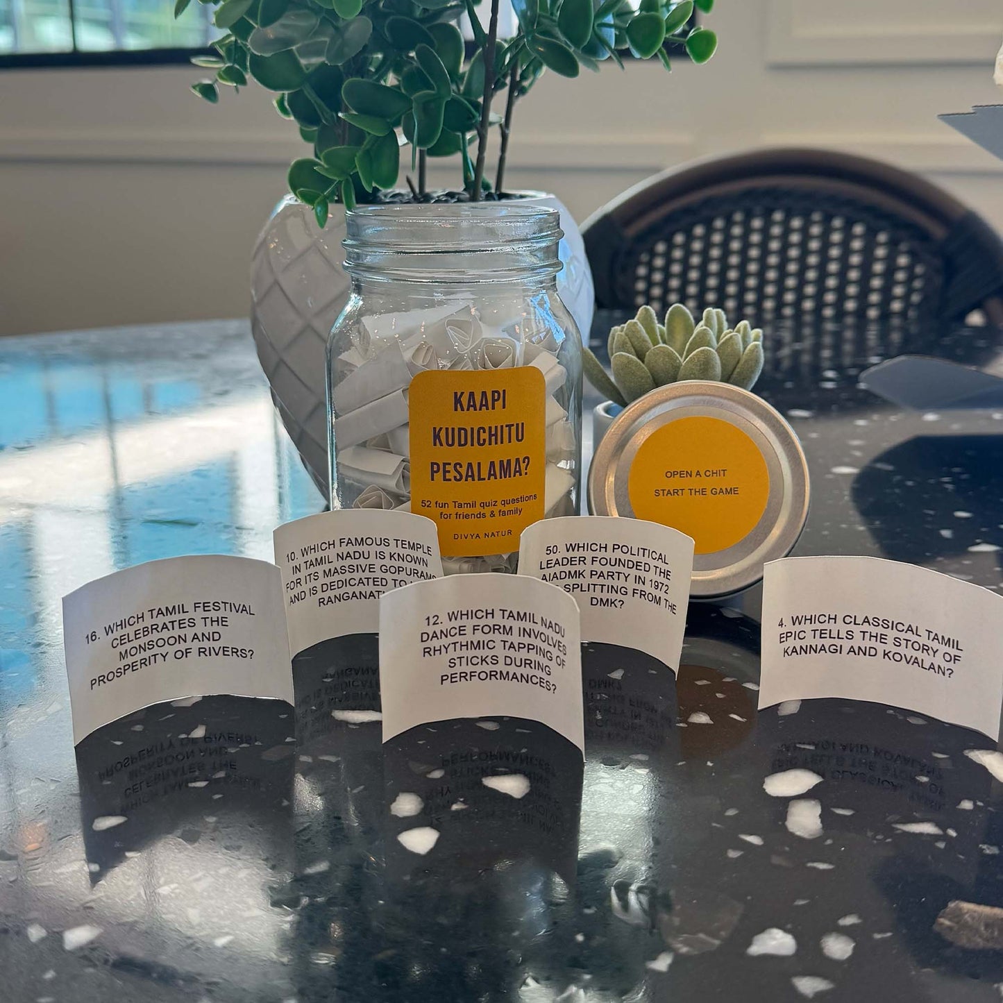 Glass jar filled with Tamil quiz chits designed for fun game nights with friends and family