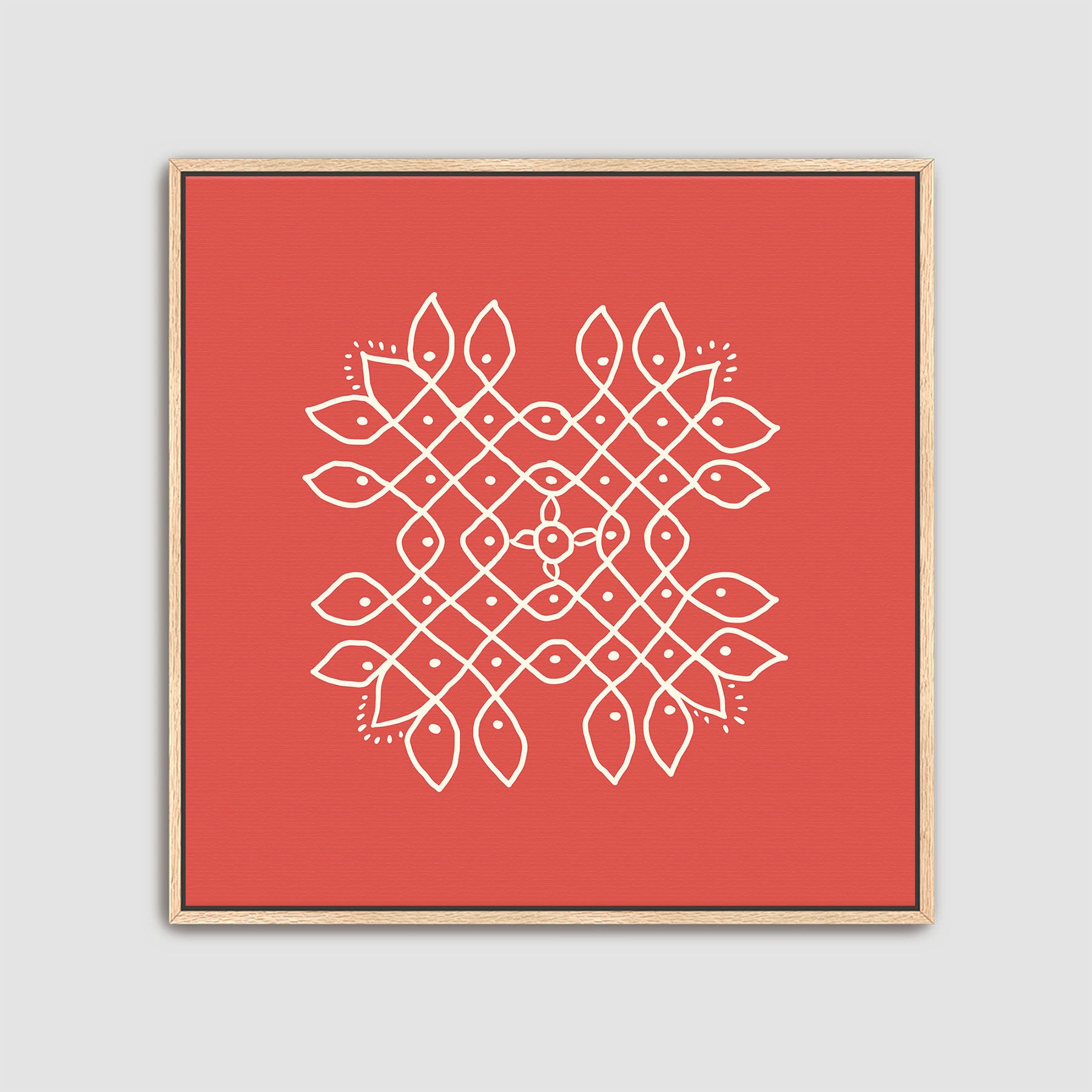 Framed artwork with a white kolam geometric pattern on a red background