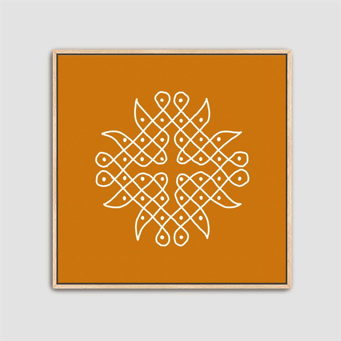 Framed artwork with a white Rangolidesign on an orange background