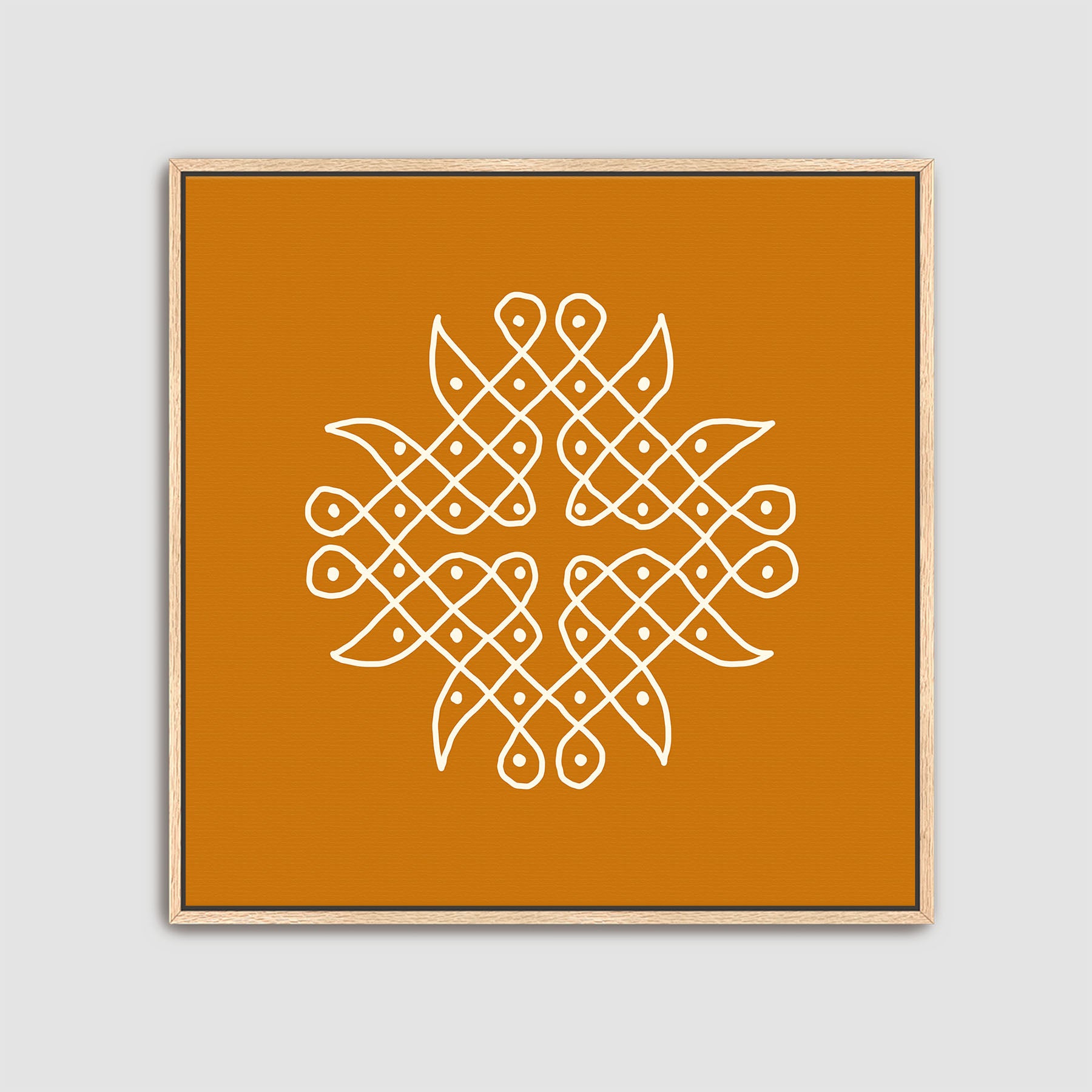 Framed artwork with a white Rangolidesign on an orange background
