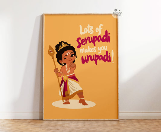 A framed tamil art print leaning against a white wall on a light wood floor. The print features a cartoon illustration of a child in traditional Indian attire holding a staff, with the text 'Lots of Serupadi makes you urupadi!' on a warm orange background.